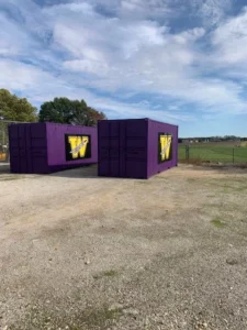Two purple containers with the letter w painted on them.